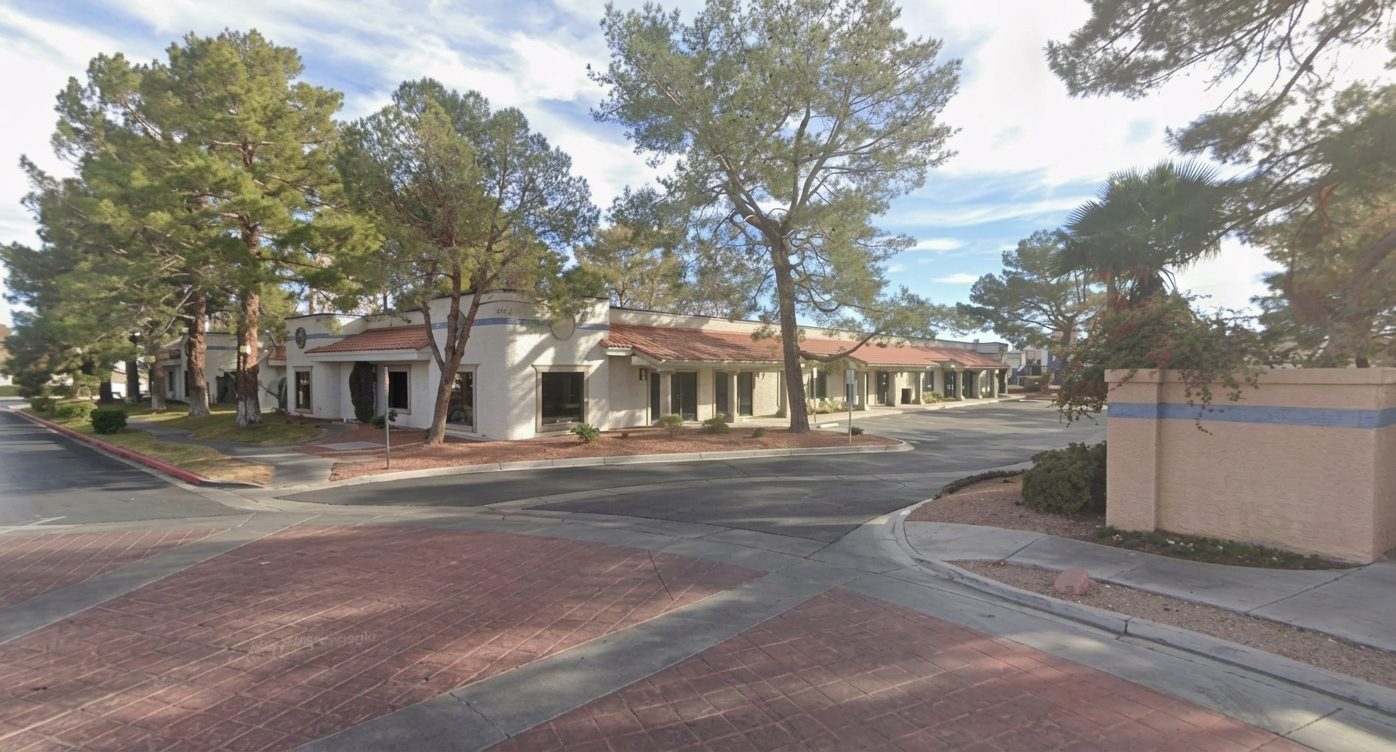 The Serenity One office on South Valley View Boulevard: a single-story building with a red tile roof, shaded by tall pine trees.